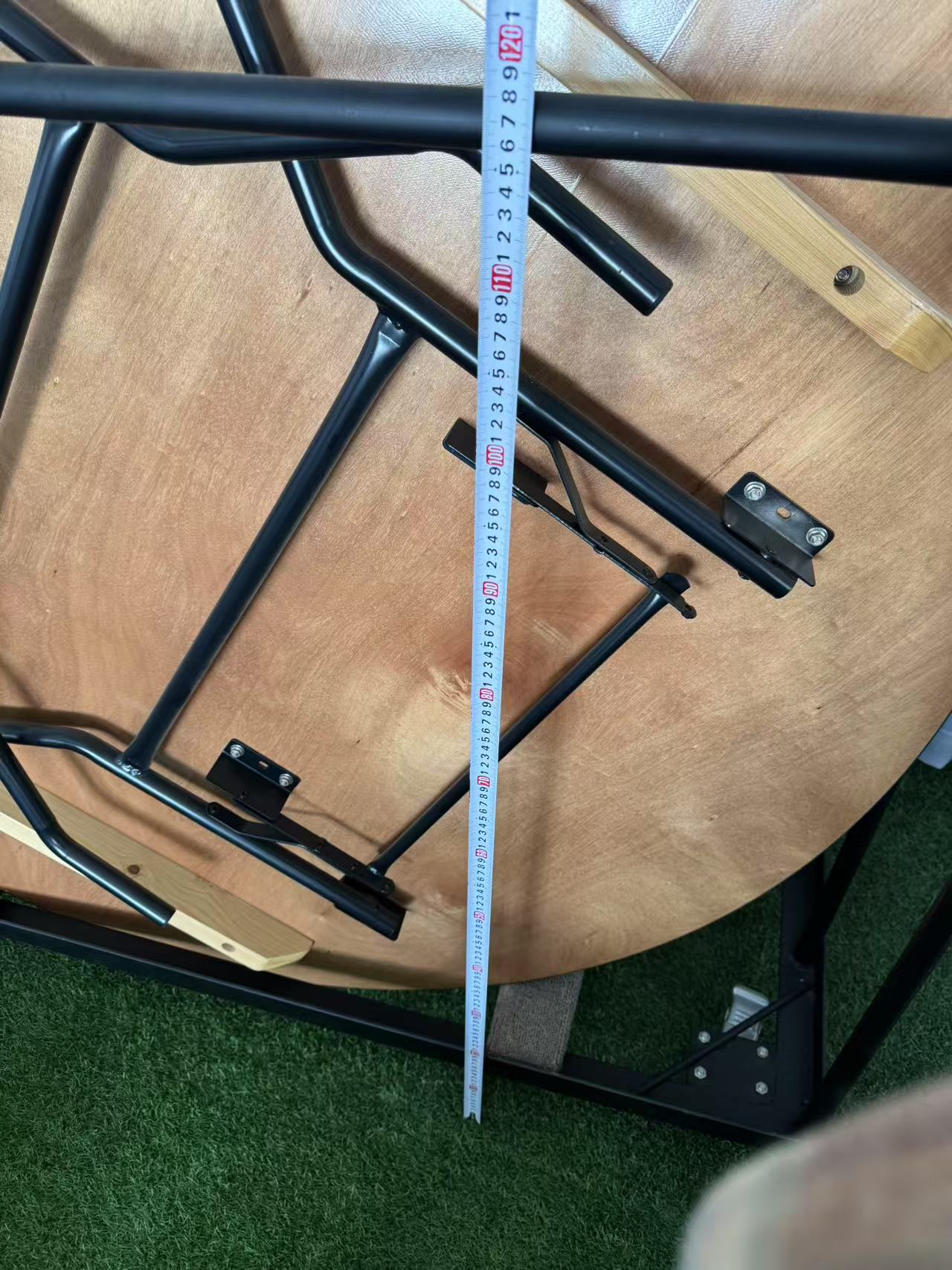 Measuring the height of the table trolley frame with a tape measure