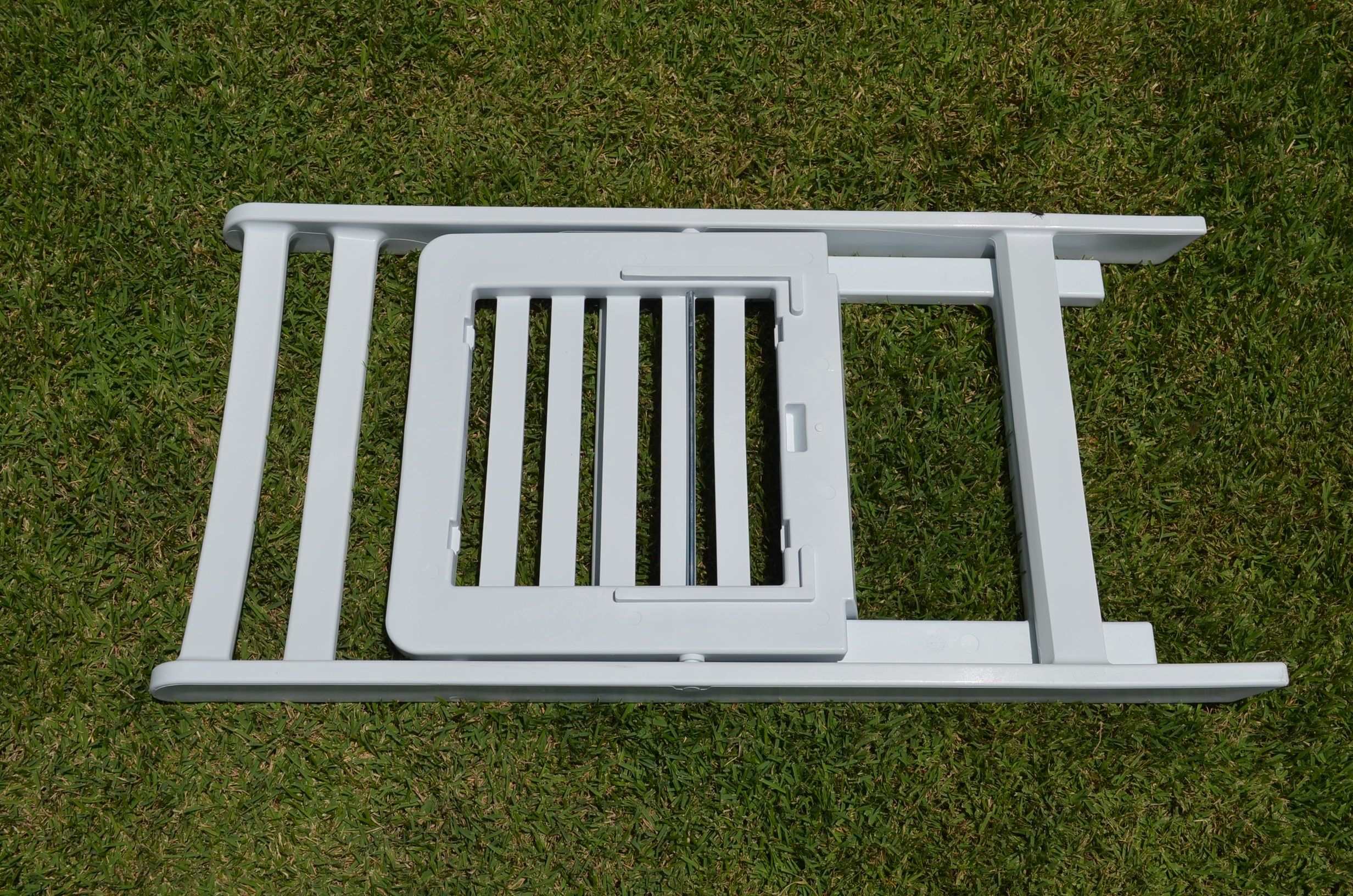 Folded white Americana resin chair on grass